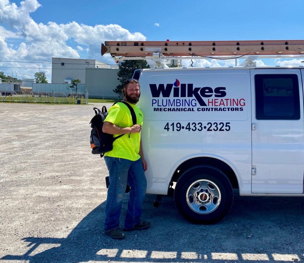 Wilkes technician with a service van and ladder at a job site