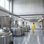 Stainless steel mixing tanks and process piping inside a paint and chemical plant